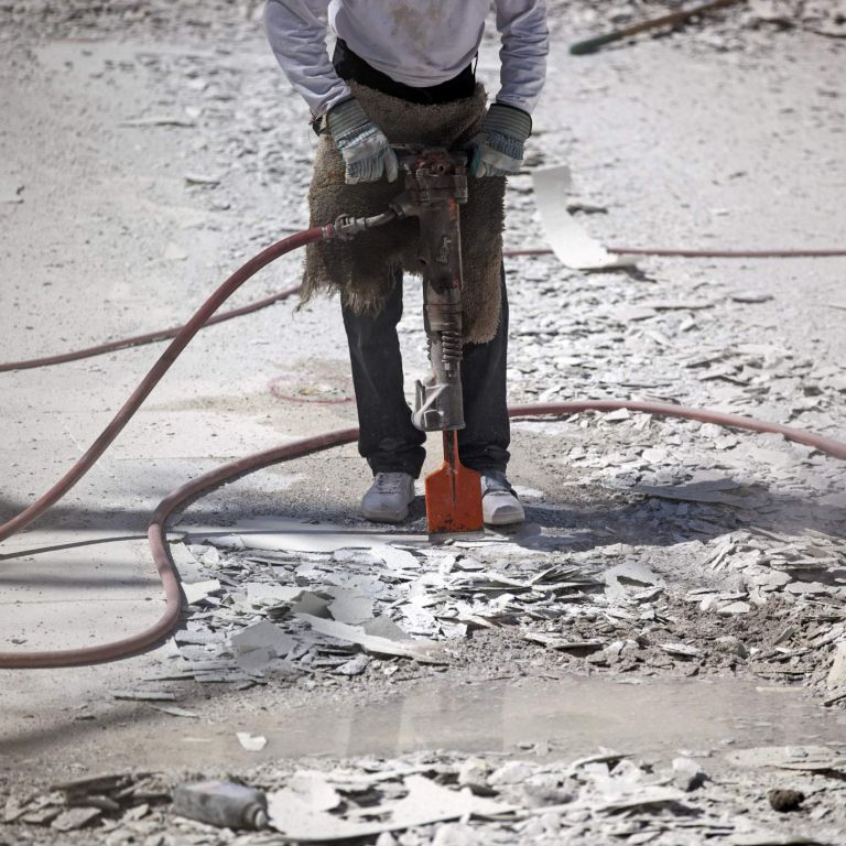 Jackhammer breaking up swimming pool for resurfacing